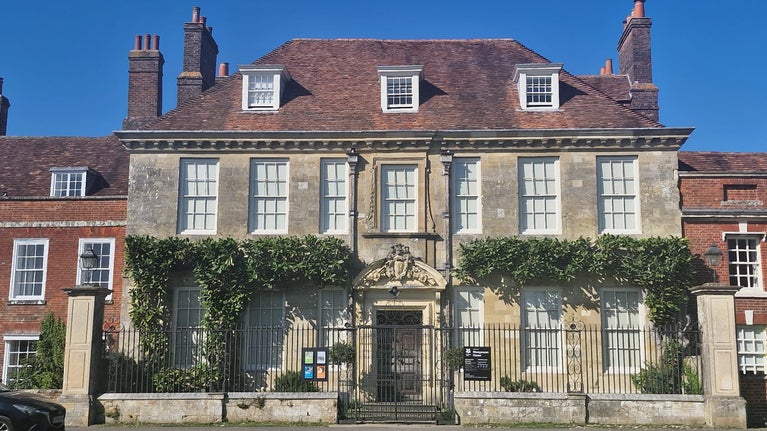 An eighteenth-century townhouse on a sunny day. Its window frames are freshly painted with white paint